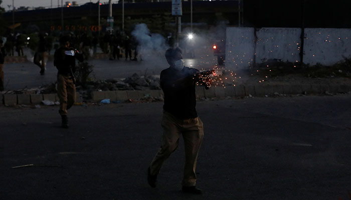 A police officer fires tear gas to disperse the supporters of former prime minister Imran Khan, during a protest against his arrest, in Karachi, Pakistan May 9, 2023. — Reuters