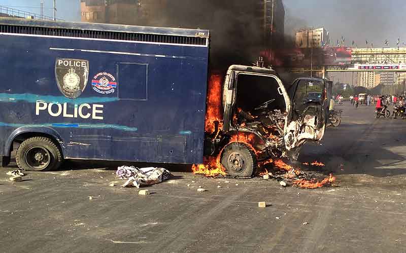9 مئی 2023 کو کراچی میں پاکستان تحریک انصاف پارٹی کے کارکنوں اور پاکستان کے سابق وزیر اعظم عمران کے حامیوں کی جانب سے اپنے رہنما کی گرفتاری کے خلاف احتجاج کے دوران ایک پولیس گاڑی کو سڑک پر جلتے ہوئے دیکھا جا رہا ہے۔