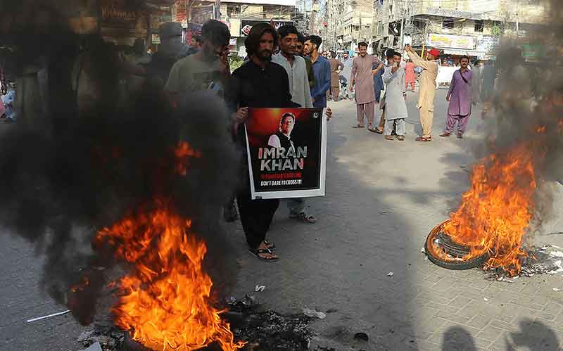 پاکستان تحریک انصاف پارٹی کے کارکن اور پاکستان کے سابق وزیر اعظم عمران کے حامی 9 مئی 2023 کو حیدر آباد میں اپنے رہنما کی گرفتاری کے خلاف احتجاج کے دوران ٹائر جلانے کے ساتھ ساتھ ایک سڑک بلاک کر رہے ہیں۔