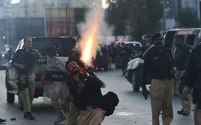 Police fire tear gas shells towards Pakistan Tehreek-e-Insaf (PTI) party activists and supporters of former Pakistan´s Prime Minister Imran during a protest against the arrest of their leader, in Karachi on May 9, 2023.