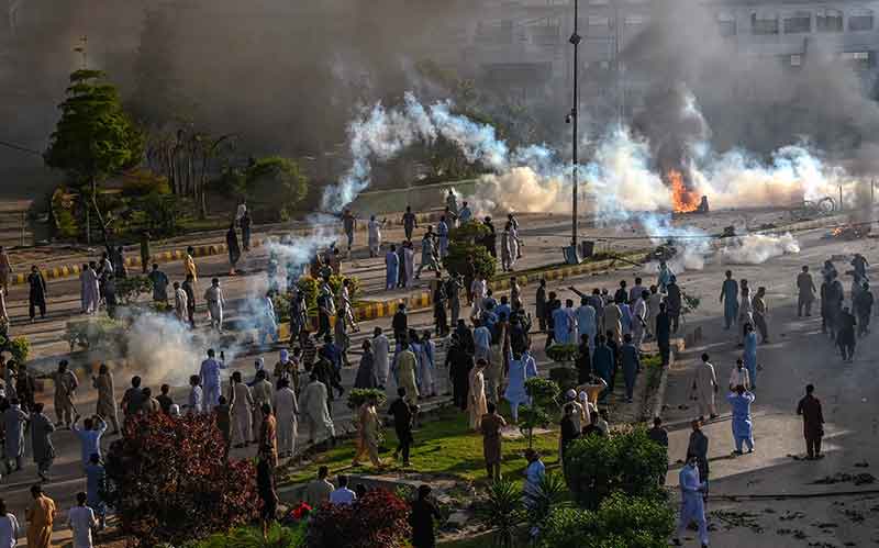 Police fire teargas shell towards Pakistan Tehreek-e-Insaf party activists and supporters of former Pakistan´s Prime Minister Imran to dispers them during a protest against the arrest of their leader in Peshawar on May 9, 2023