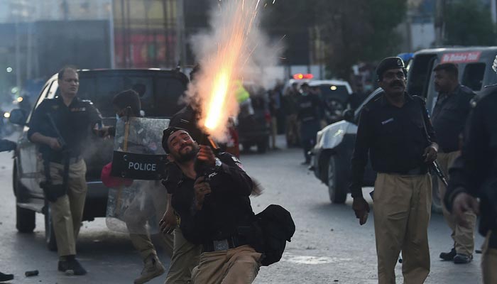 Police fire tear gas shells towards PTI party activists and supporters of former prime minister Imran Khan during a protest against the arrest of their leader, in Karachi on May 9, 2023. — AFP
