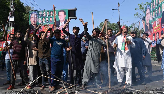 PTI party activists and supporters of former prime minister Imran Khan shout slogans during a protest against the arrest of their leader, in Lahore on May 9, 2023. — AFP