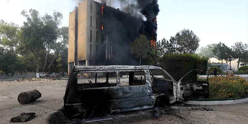 Smoke billows from a Radio Pakistan building next to a burnt vehicle after it was set afire by the supporters of Pakistans former Prime Minister Imran Khan during a protest against his arrest, in Peshawar, Pakistan, May 10, 2023. — Reuters