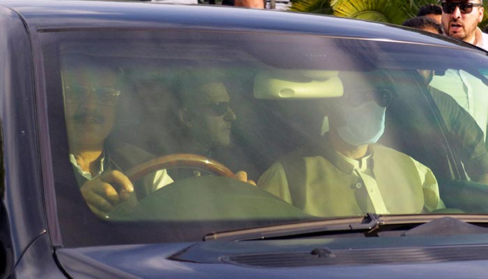 A car carries former prime minister Imran Khan, as he arrives to appear before the Supreme Court in Islamabad on May 11, 2023. — AFP