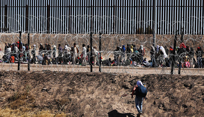 A migrant man crosses through the banks of the Rio Grande to be processed by the Border Patrol El Paso Sector, Texas after crossing from Ciudad Juarez, Mexico on May 10, 2023. — AFP