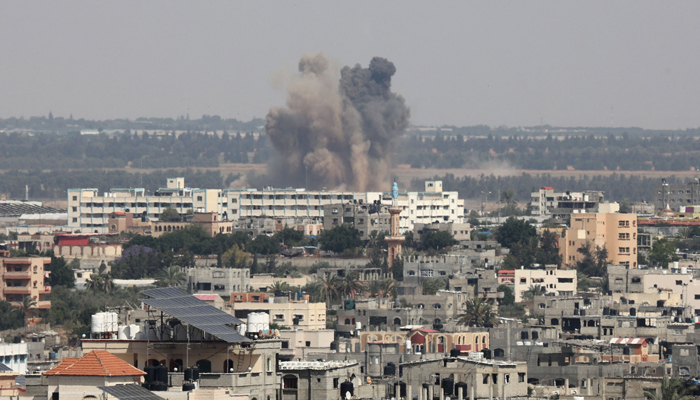 A plume of smoke rises above buildings during an Israeli strike east of Rafah, in the southern Gaza Strip, on May 11, 2023. — AFP