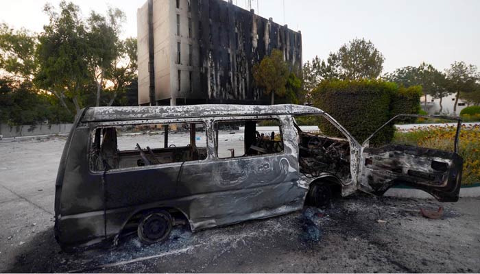 A view of the Radio Pakistan building and vehicle after they were set to fire by angry PTI protestors after the arrest of PTI Chairman Imran Khan. — INP