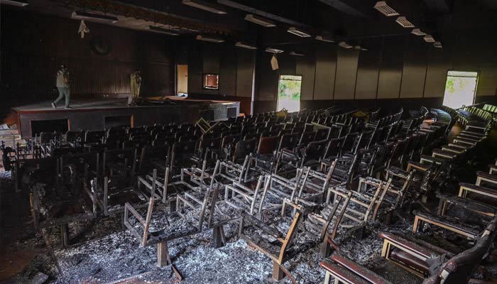 A man stands inside the burnt auditorium of the Radio Pakistan building a day after protests by PTI party activists and supporters in Peshawar on May 11, 2023. — AFP