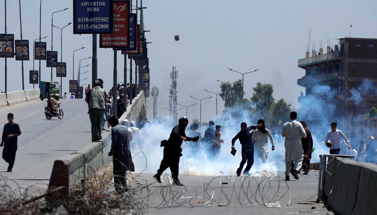 Supporters of Pakistans former Prime Minister Imran Khan throw stones towards police during a protest against Khans arrest, in Peshawar, Pakistan, May 10, 2023. — Reuters