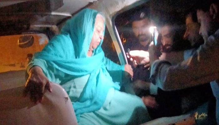 PTI leader Dr. Yasmin Rashid is escorted out of an ambulance.  Twitter