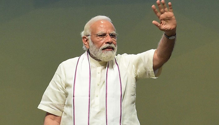 Indian Prime Minister Narendra Modi waves during an event where housing is provided to people in need in Gandhinagar, some 30km from Ahmedabad on May 12, 2023. — AFP