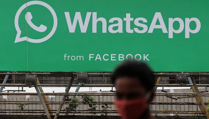 A man walks past a hoarding of the WhatsApp application installed at a skywalk in Mumbai, India, August 26, 2021. — Reuters