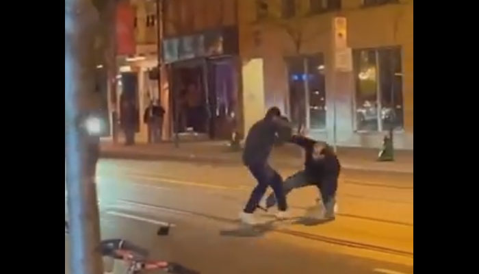 A man strikes a person with his pet python on a street in Canada. — Twitter/ crazyclipsonly