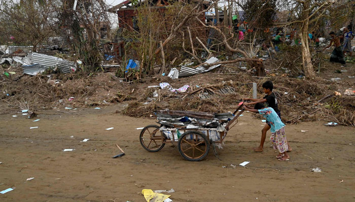 Children push a cart full of debris at the Khaung Dote Khar Rohingya refugee camp in Sittwe, in Myanmars Rakhine state, on May 15, 2023. — AFP