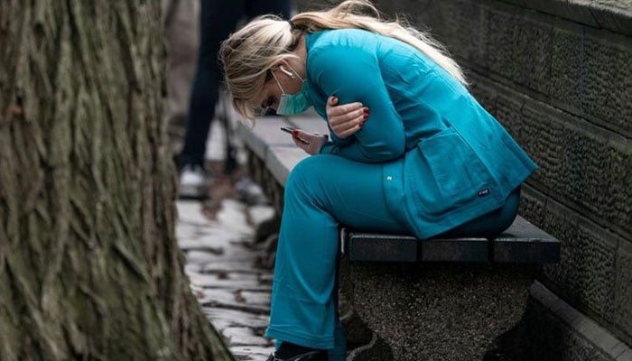 A healthcare worker sits on a bench near Central Park in the Manhattan borough of New York City, US. — Reuters/File