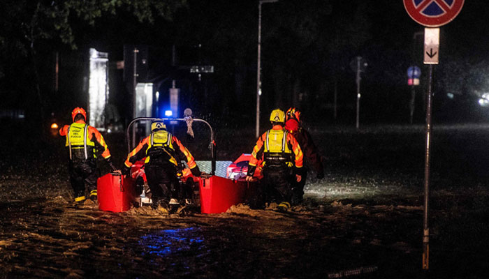 Brandmænd og civilbeskyttelses- og redningsarbejdere evakuerer beboere i en gummibåd i Forlì efter kraftig regn forårsager massive oversvømmelser i det centrale Italien den 17. maj 2023.  — AFP