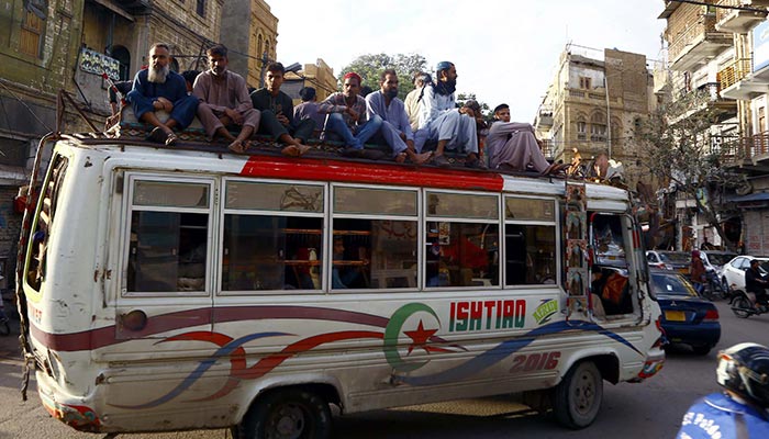 Passengers travelling onboard an overloaded bus in Karachi, on March 23, 2023. — PPI