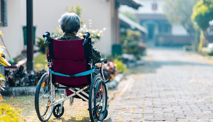 An old woman can be seen sitting in a wheelchair alone. — Unsplash/File