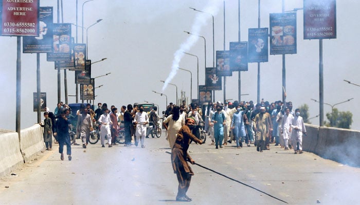 A supporter of Imran Khan throws stones towards police during a protest against Khans arrest, in Peshawar, Pakistan, May 10, 2023. — Reuters.