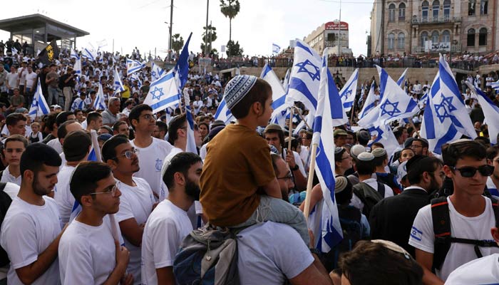 Israelis waving national flags gather outside the Damascus Gate of the Old City of Jerusalem during the annual flag march to mark Jerusalem Day on May 18, 2023. — AFP