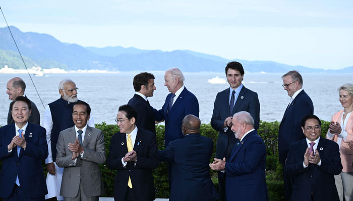 Frances President Emmanuel Macron (centre L) speaks with US President Biden after a family photo of leaders of the G7 and invited countries during G7 Leaders Summit in Hiroshima on May 20, 2023. — AFP