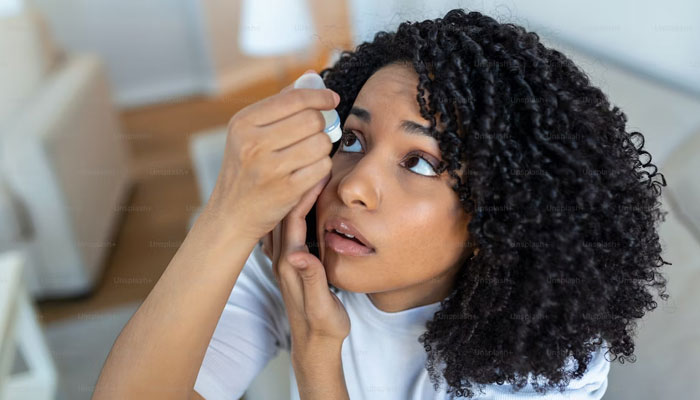 A representational image of a woman putting an eye drop into her eyes. — Unsplash/File