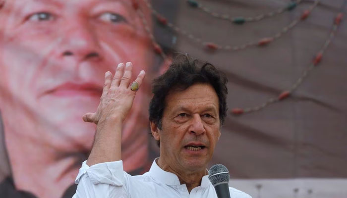 پاکستان تحریک انصاف (پی ٹی آئی) کے چیئرمین عمران خان، کراچی، پاکستان، 4 جولائی، 2018 کو عام انتخابات سے قبل ایک مہم کے اجلاس کے دوران اپنے حامیوں سے خطاب کرتے ہوئے اشارہ کر رہے ہیں۔ — رائٹرز