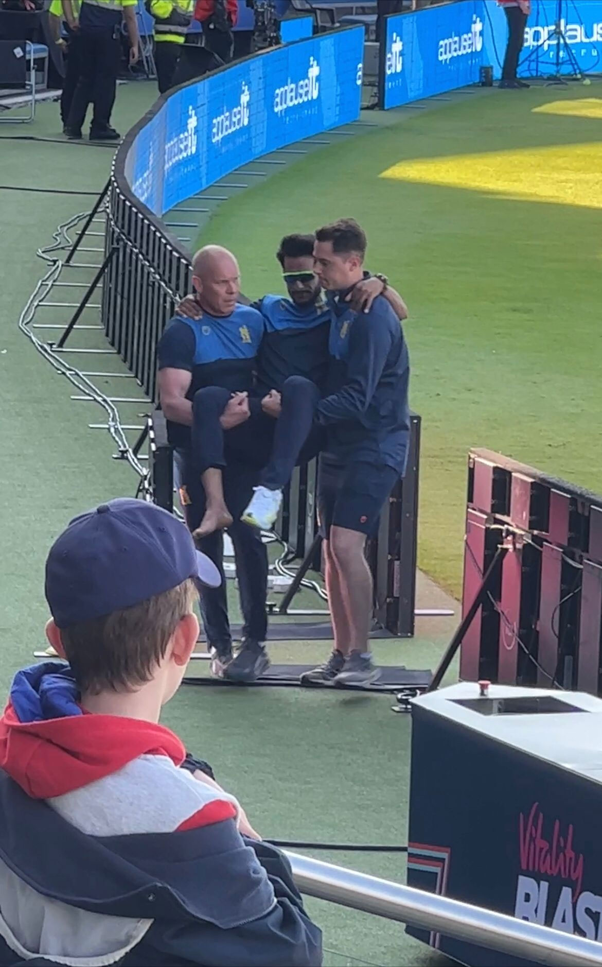 The Birmingham Bears staff assisting Hasan Ali off the ground following the injury.