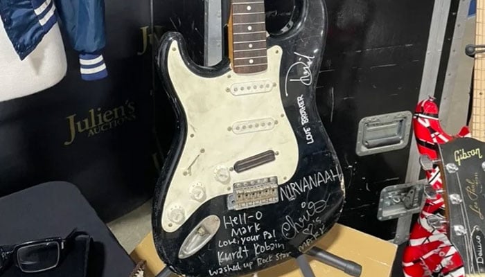 The busted black Fender Stratocaster has been put back together but is no longer playable. Twitter/Julien’s Auctions