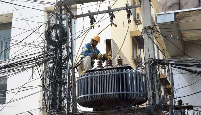 A WAPDA worker is fixing electricity wires on a pole mounted transformer along the Devious Road in Lahore on April 2, 2023. — Online