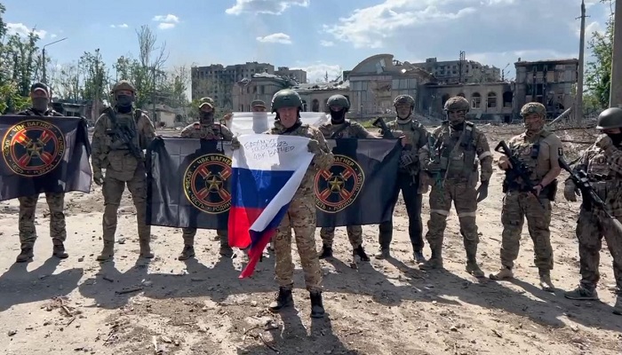 This video grab shows Yevgeny Prigozhin holding a Russian national flag in front of his soldiers holding Wagner Groups flags in Bakhmut.—AFP