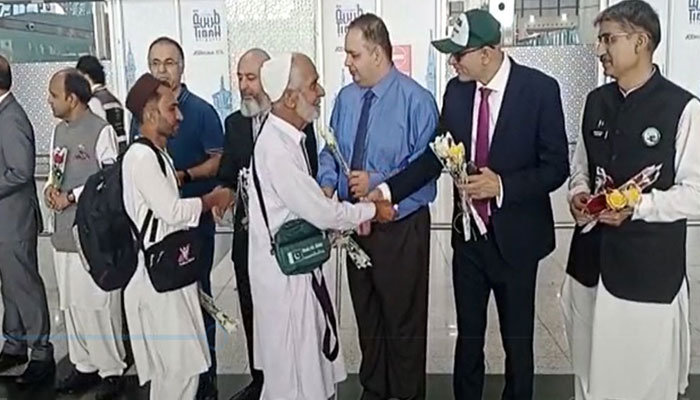 Officials from Pakistani Hajj mission welcome pilgrims upon their arrival at Madina airport. — Radio Pakistan