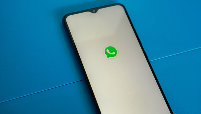 The picture shows the WhatsApp logo on a mobile phone. — Unsplash