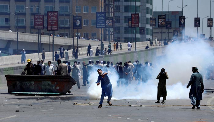 Supporters of former prime minister Imran Khan throw stones at police during a protest against Khans arrest, in Peshawar, Pakistan, May 10, 2023. — Reuters
