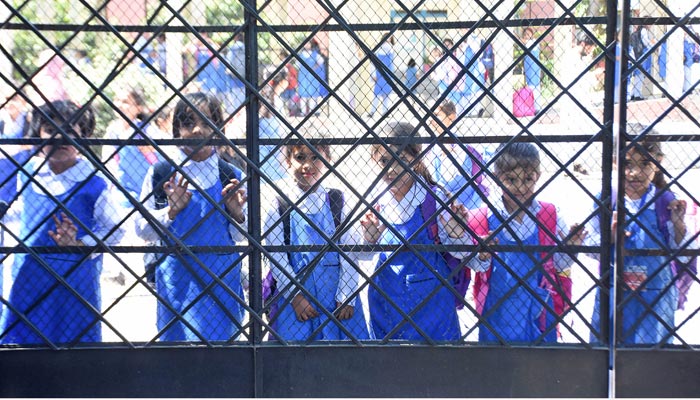 Female students are waiting for their parents after school timing in Islamabad on May 10, 2023. — Online