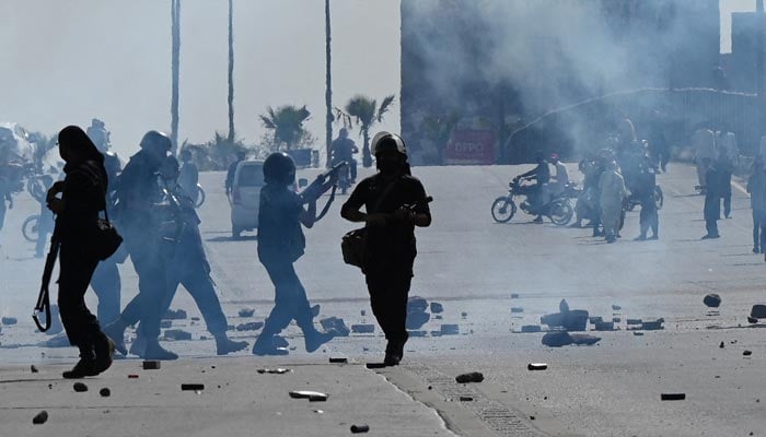 Policemen fire teargas shells to disperse PTI party activists and supporters of former prime minister Imran Khan trying to reach the Islamabad High Court during Khan´s hearing, in Islamabad on May 12, 2023. — AFP