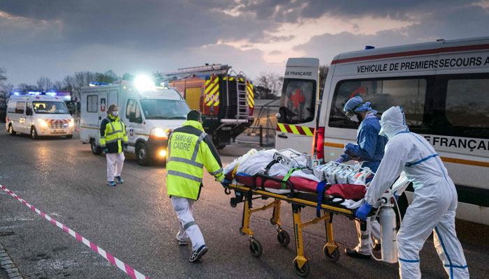 Petugas medis darurat membawa pasien yang terkena virus corona (COVID-19) dari rumah sakit militer ke ambulans.  —AFP/Berkas