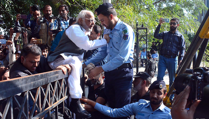 Police officials stop PTI leader Ejaz Chaudhry from entering the Election Commission of Pakistans Islamabad office on October 21, 2022. — INP