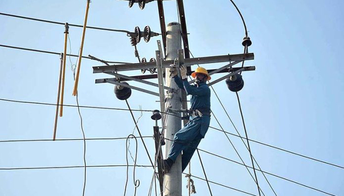 A Faisalabad Electric Supply Company (Fesco) worker removes faults from an electricity line on December 19, 2022. — APP