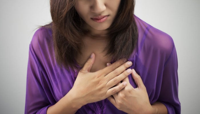 A representational image of a woman having a heart attack. — Canva