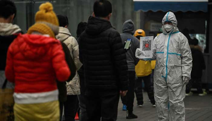 People queue to test for the Covid-19 coronavirus at a swab collection station in Beijing on November 20, 2022. — AFP