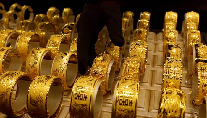 A salesperson arranges 24 carats gold bracelets for Chinese weddings at Chow Tai Fook Jewellery store in Hong Kong, China December 14, 2017. — Reuters