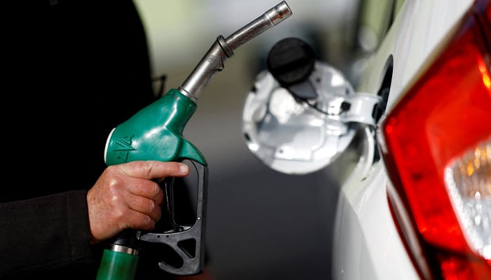 A man holds a fuel nozzle at a petrol station in Reze, near Nantes, France, March 18, 2022. — Reuters