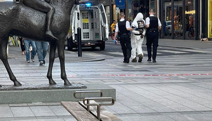 Man being taken away by police wearing a white hazmat suit carrying Black Lives Matter slogans. —Screengrab of a video provided by the reporter