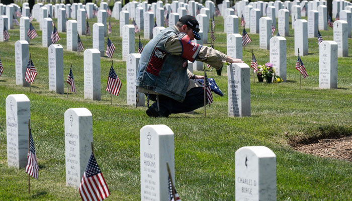 A man takes a moment at a headstone he was visiting at in section 60 in Arlington National Cemetery before the Memorial Day weekend in Arlington, Virginia on May 26, 2023. — AFP