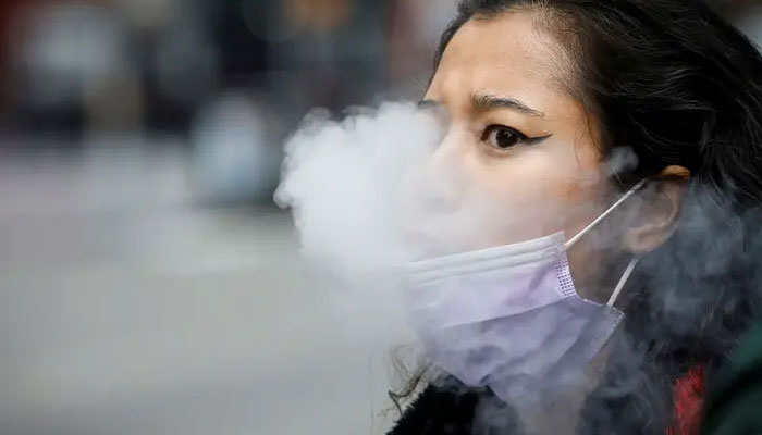 A woman exhales after vaping in Times Square, during the coronavirus outbreak, in New York City, US, March 31, 2020. Reuters