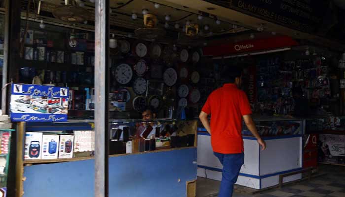 Shopkeepers sit at their shops amid prolonged electricity loadshedding in Karachis Saddar area on Thursday, August 11, 2022. — PPI