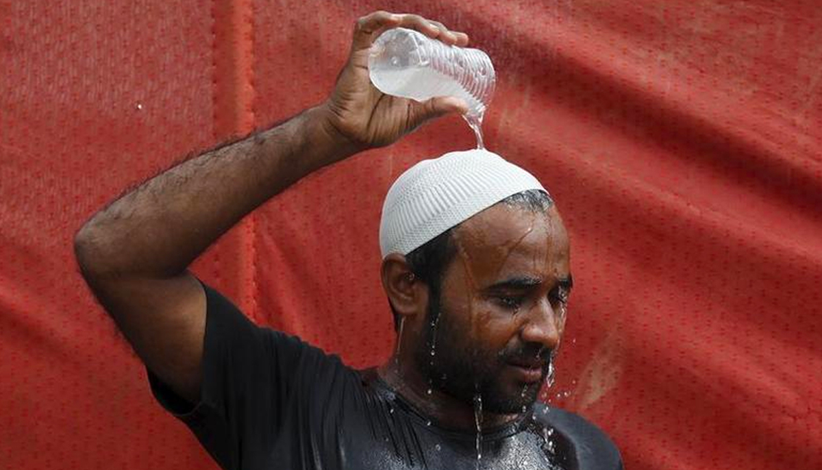 A man pours water on his head to cool off from the heat in Karachi, Pakistan, June 25, 2015. — Reuters