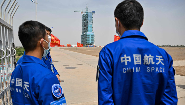 Staff members from the China space program stand before the launch platform of the Shenzhou-16 Manned Space Flight Mission one day before launch at the Jiuquan Satellite Launch Centre in Chinas northwestern Gansu province on May 29, 2023. — AFP